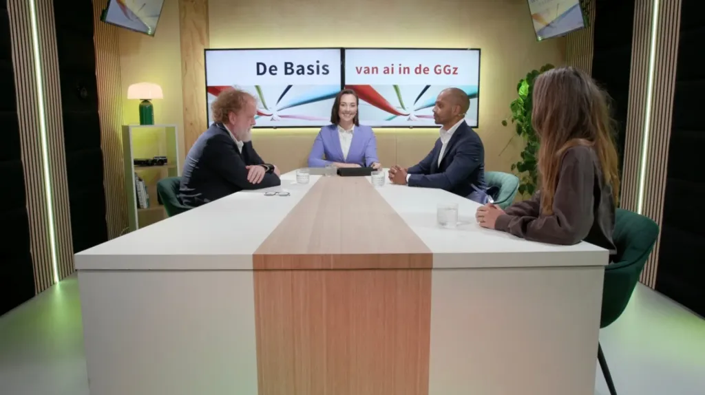 Presentator en drie gasten aan de tafel in de webinarstudio tijdens het webinar De basis van AI in de GGz